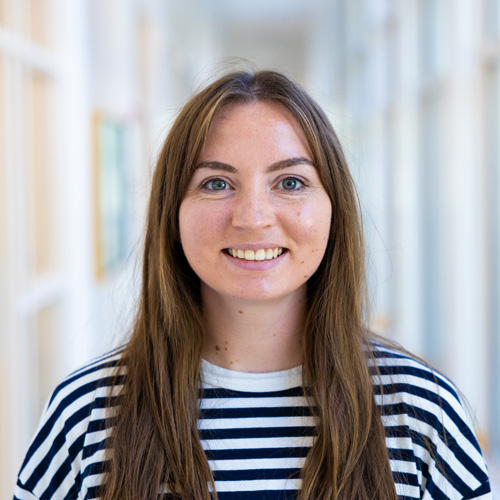 Female college student in a long hallway.