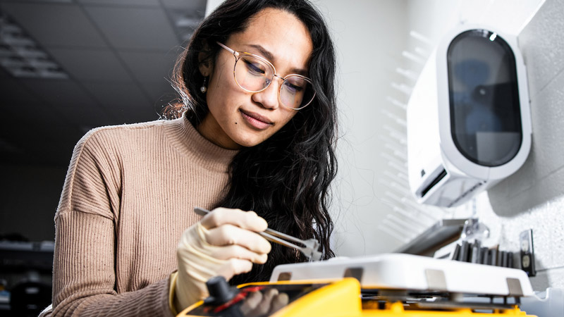 Female BYU engineering student working in an engineering lab.