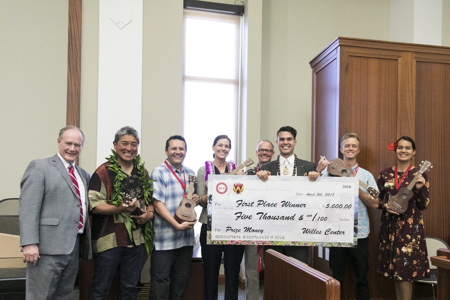 Group of people posing with a large check