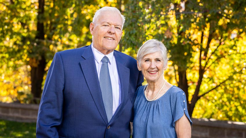 A couple in front of some trees