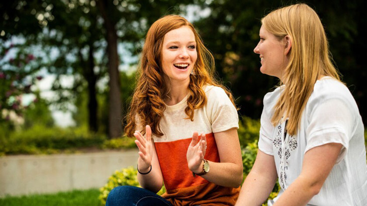 Two female BYU students talking outside