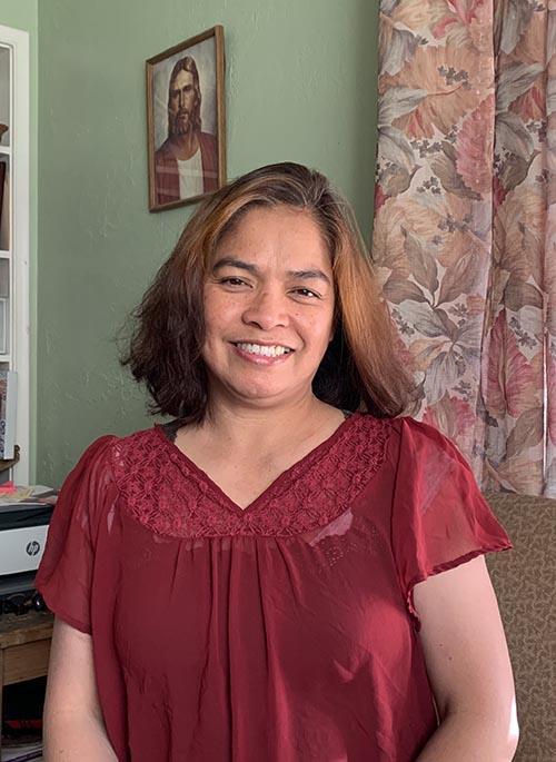 woman standing in her home in front of picture of Jesus Christ