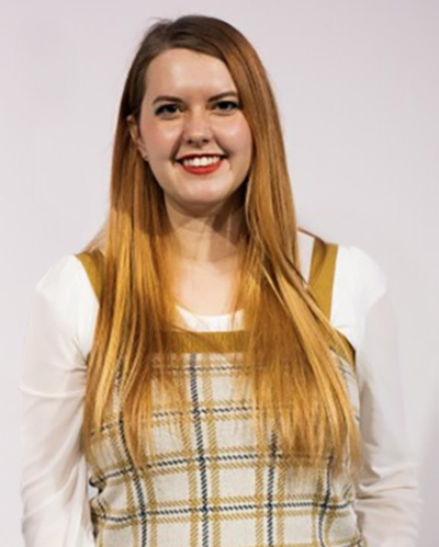 Abbie Speed smiling against a white wall