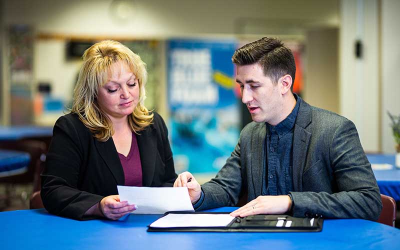 Zach Parker and Angela Blomquist review a document.