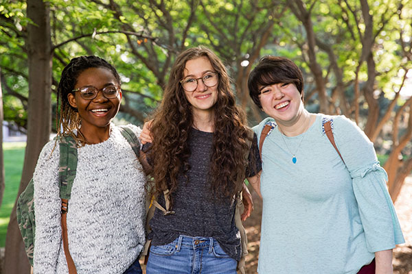 students three BYU-Idaho students standing in front of trees