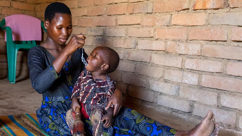 African woman feeding her child.