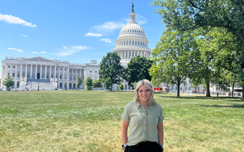 A young woman in front of government buildings