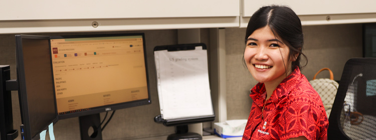 Francine San Gabriel working at a computer in an office