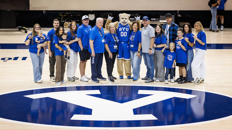 Cosmo Cougar with a PLC family on the BYU basketball court