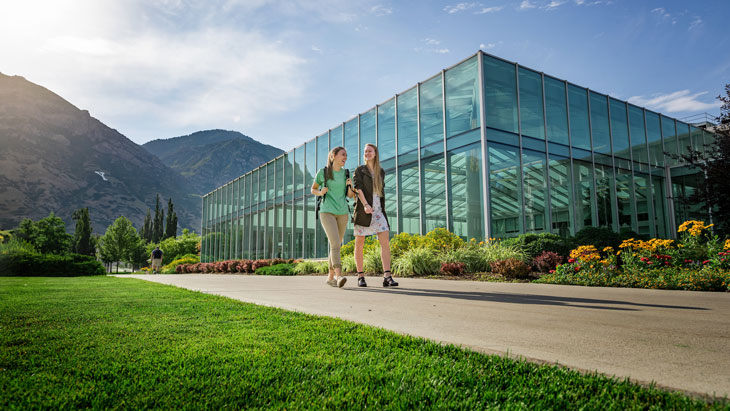 Two female students walking on BYU campus in summertime.