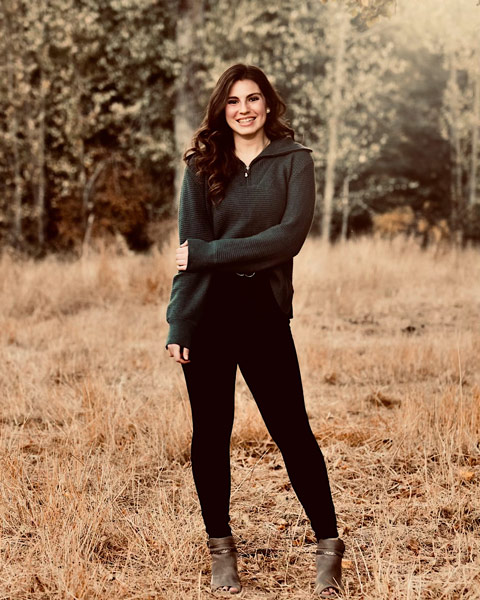 Brielle Schurger outdoors in front of trees in the fall