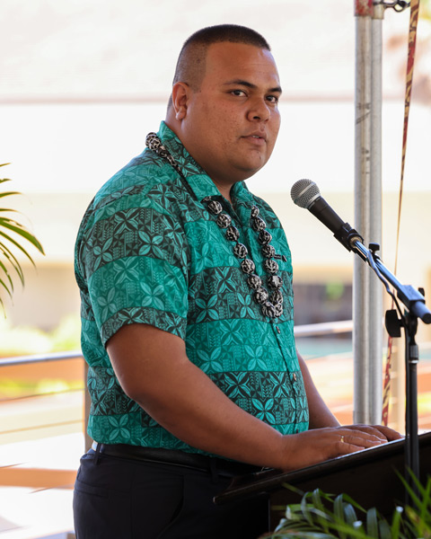 Temwake speaking at an outdoor event in front of a microphone