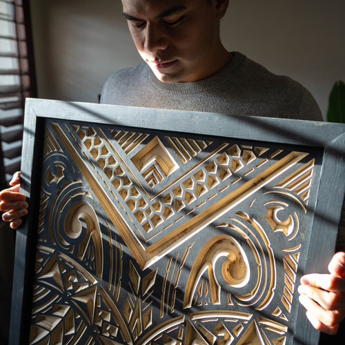 Talavou Fitisemanu holding his Polynesian art piece