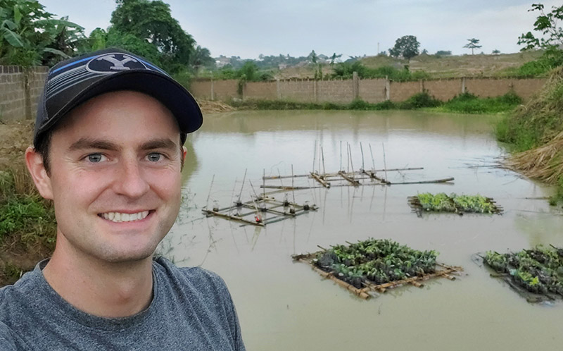 young man standing by a pond in Ghana